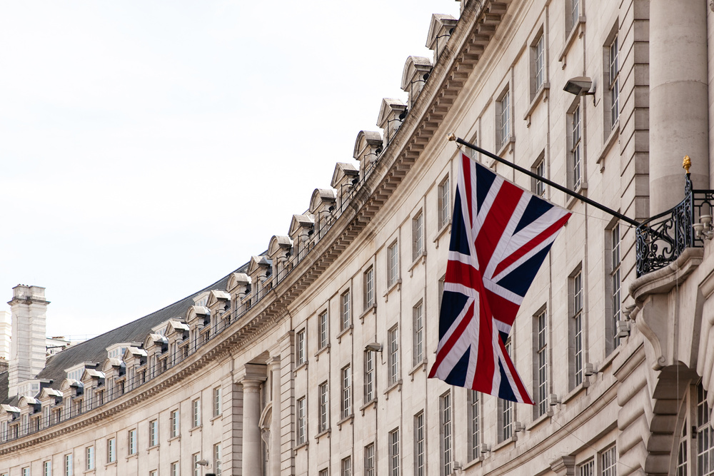 British flag on the background of the historic building of London, UK
