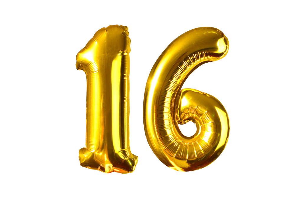 Happy 16 years old party with golden shiny inflatable balloons isolated on white