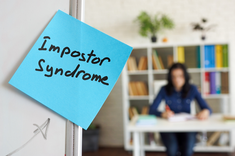 Impostor syndrome written on the sticker on the whiteboard.