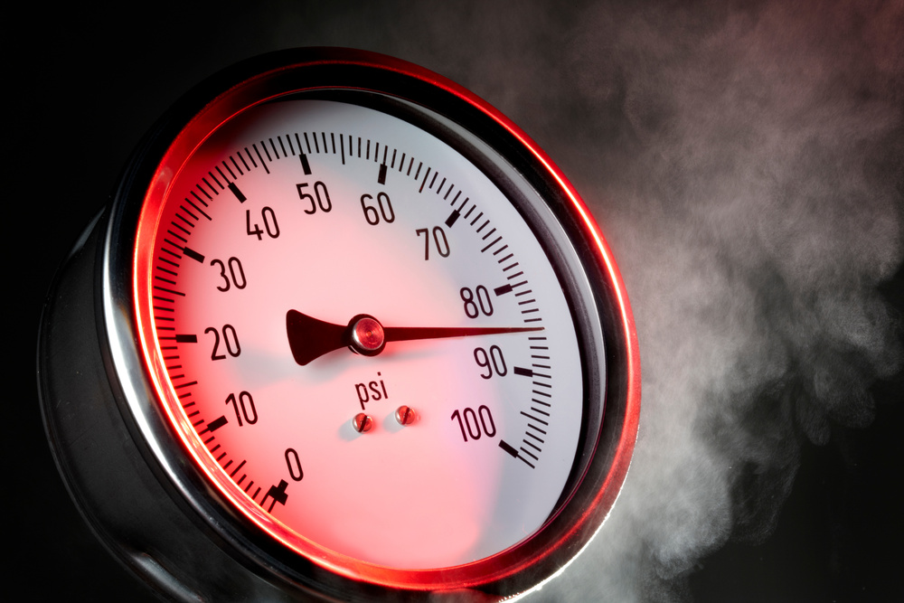 pressure gauge under extreme stress with steam and red warning light