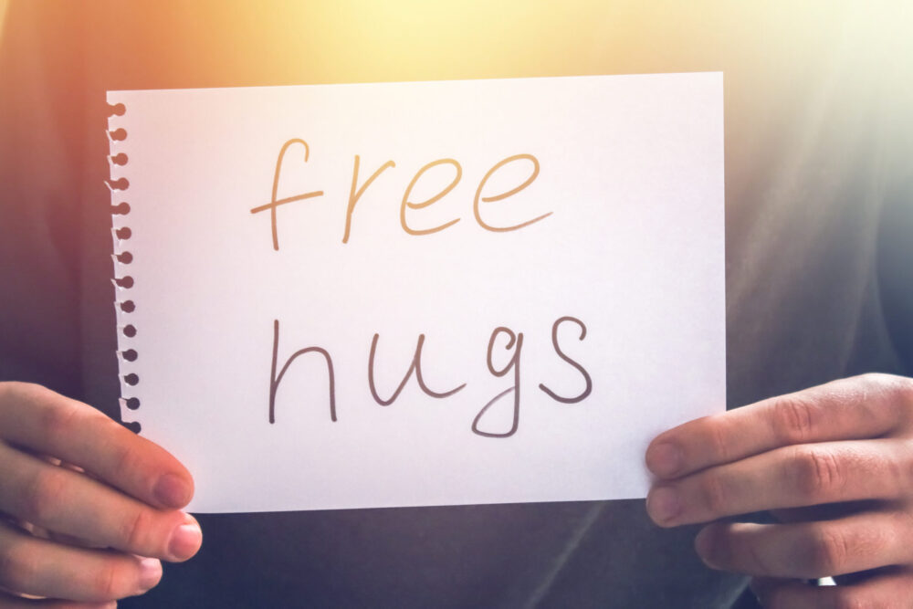 A man holds a note with the inscription - Free hugs. Holiday concept to the International Day of hugs