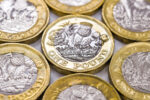 Close up view of British currency GBP - One Pound coin surrounded by other coins