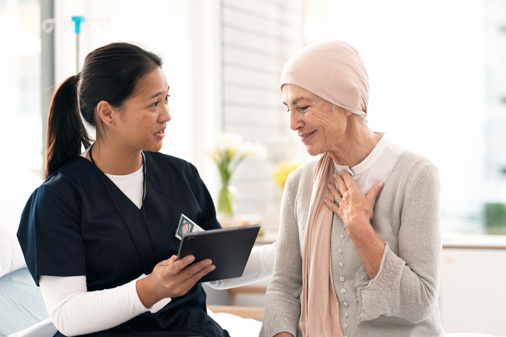 Tablet, nurse and woman with cancer patient, elderly and hospital consultation for wellness. Tech, happy and medical professional with sick senior person coughing for advice, healthcare or support