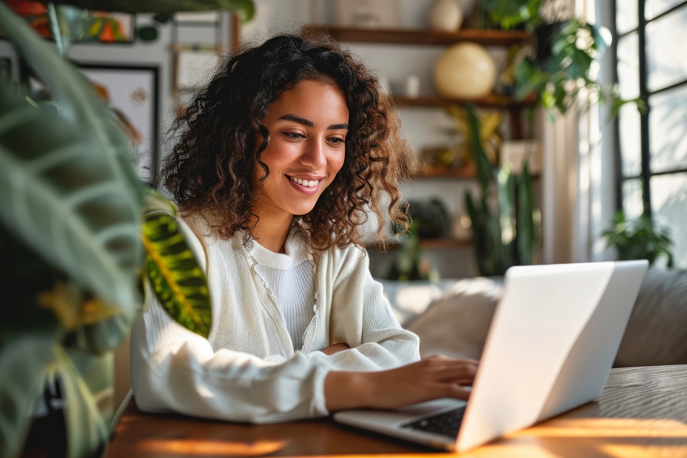 Young happy latin woman, smiling curly casual girl student using tablet and laptop elearning or hybrid working at home online looking at tab device sitting at table in living room, Generative AI