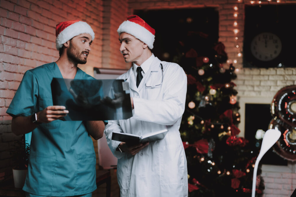 Two Doctors in Red Caps with X-ray Scan in Office.