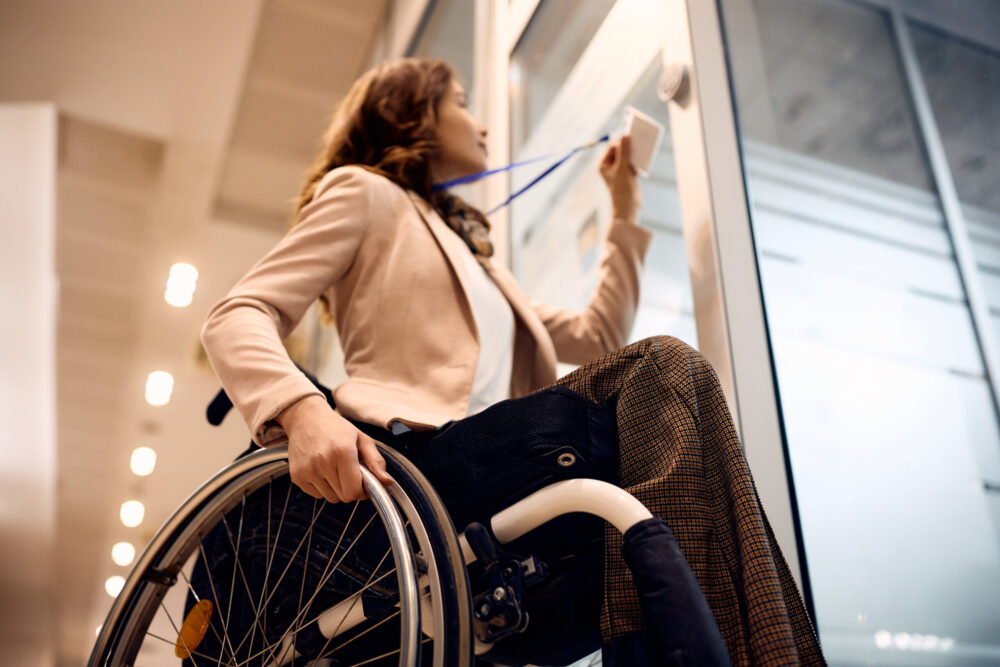 Close up of businesswoman with disability using ID card to enter in the office.