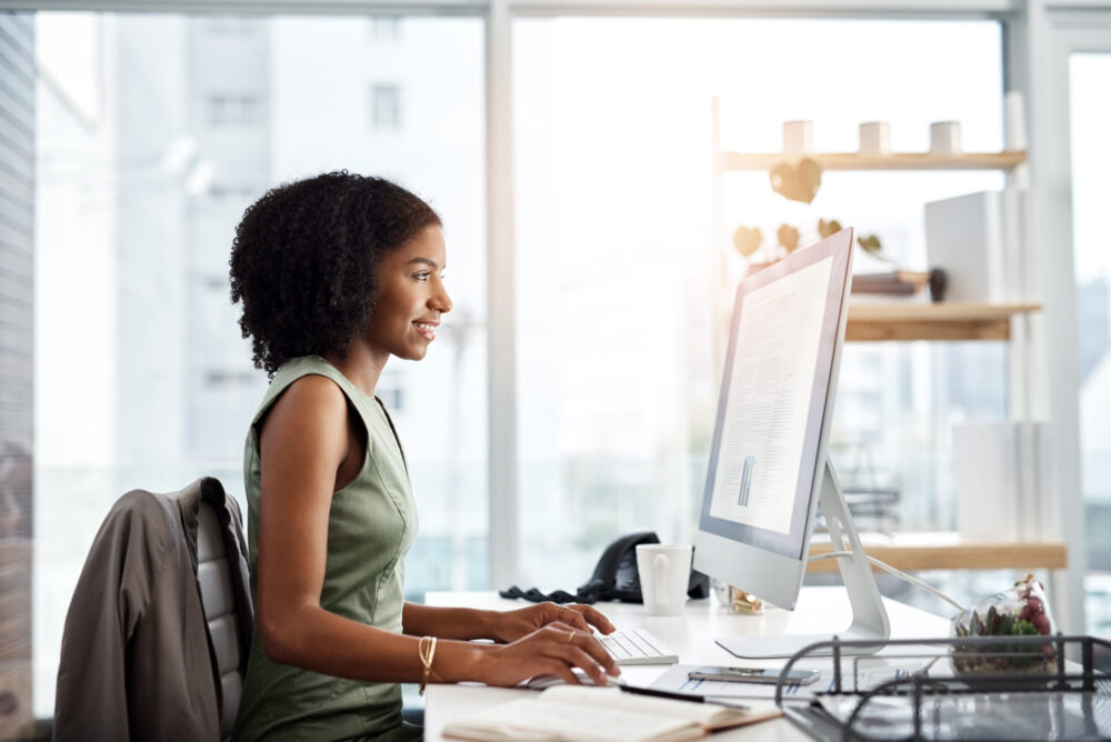 Black woman in business, reading on computer screen and analysis with project information and article. Data analyst, review of corporate report and happy female employee in office with productivity