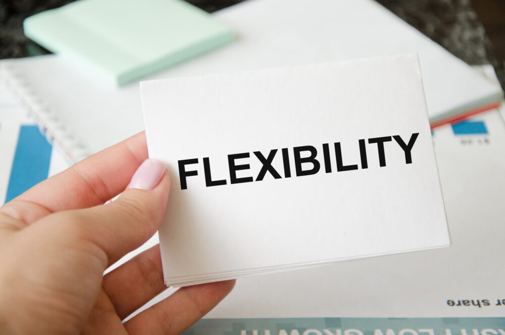 word flexibility written on a white sheet of paper held by a girl