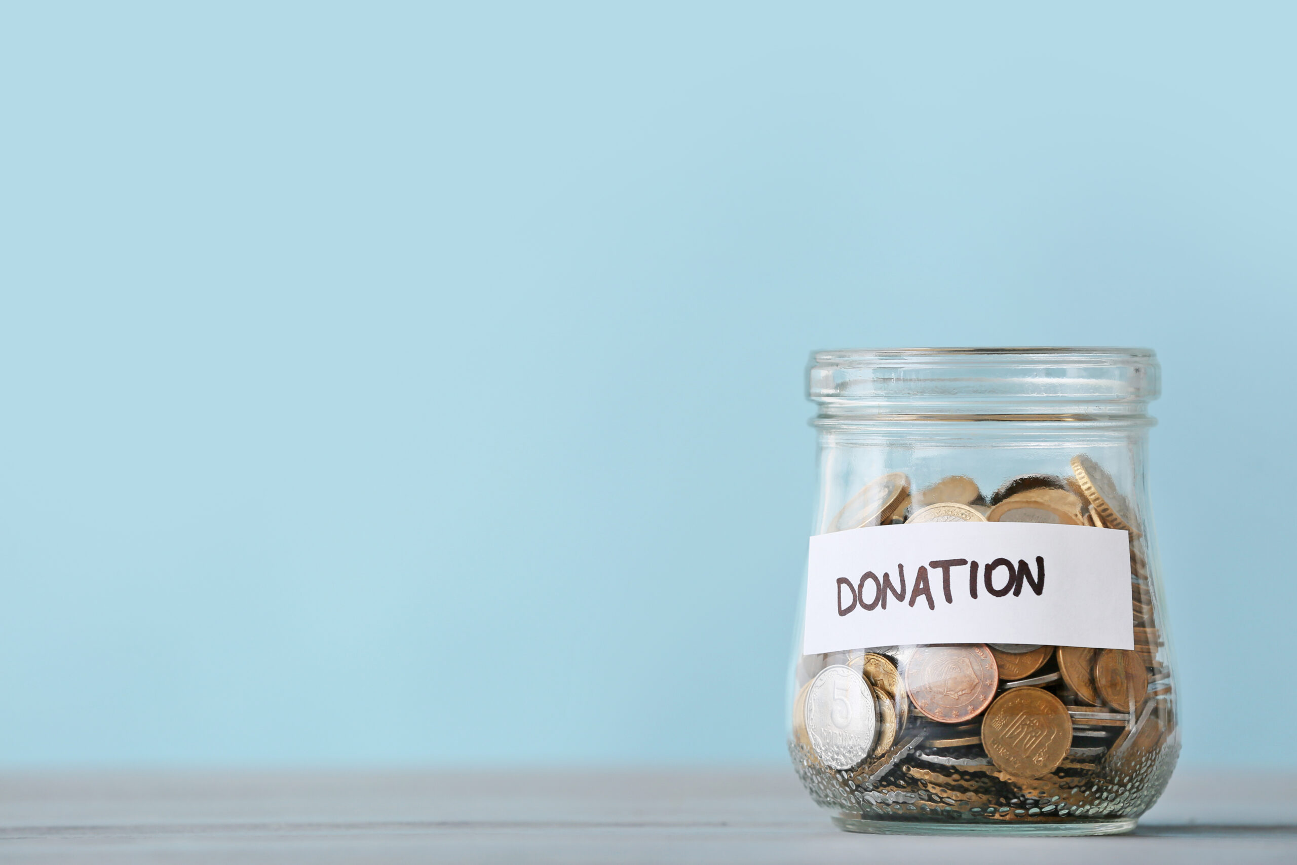 Pot of money labelled “donation” representing charitable funding for mental health charity Mind