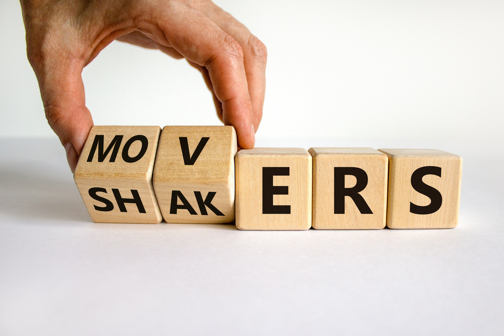 Movers and Shakers symbol. Businessman hand turns cubes and changes the word 'shakers' to 'movers'. Beautiful white background. Business and Movers and Shakers concept. Copy space.