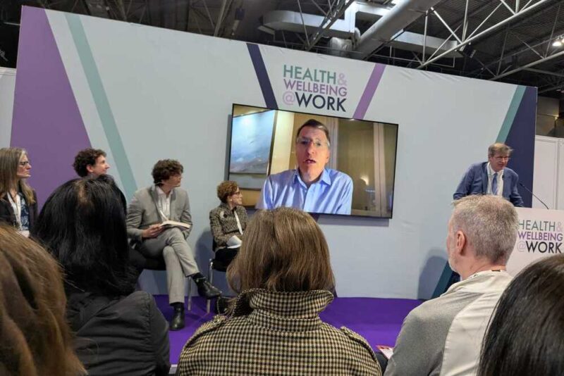Opening keynote panel at Health and Wellbeing at Work 2026 featuring Professor Dame Carol Black and Sir Charlie Mayfield speaking on workplace health and policy