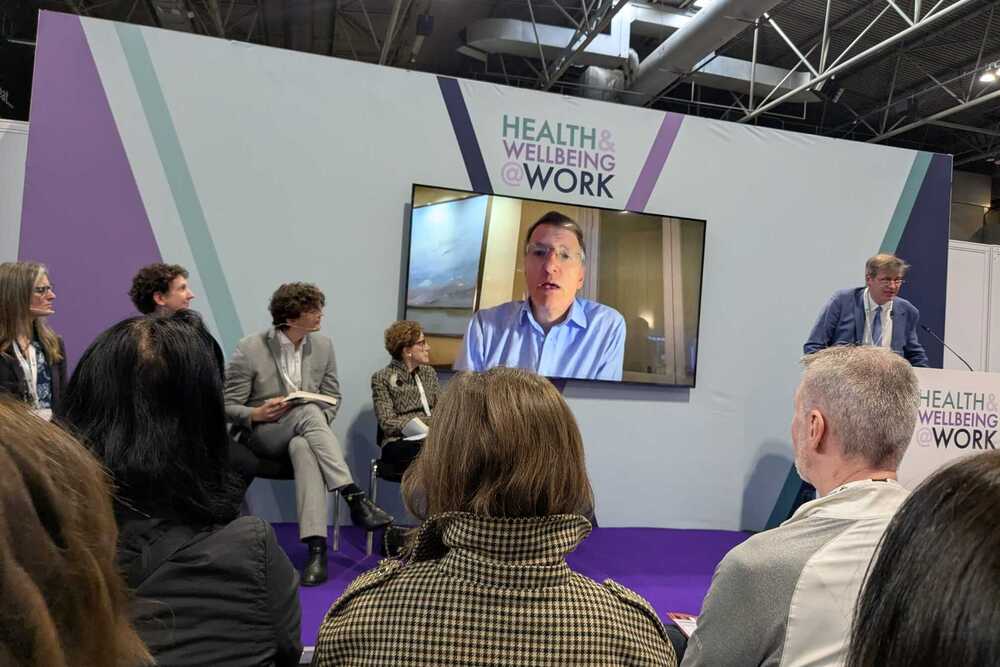 Opening keynote panel at Health and Wellbeing at Work 2026 featuring Professor Dame Carol Black and Sir Charlie Mayfield speaking on workplace health and policy
