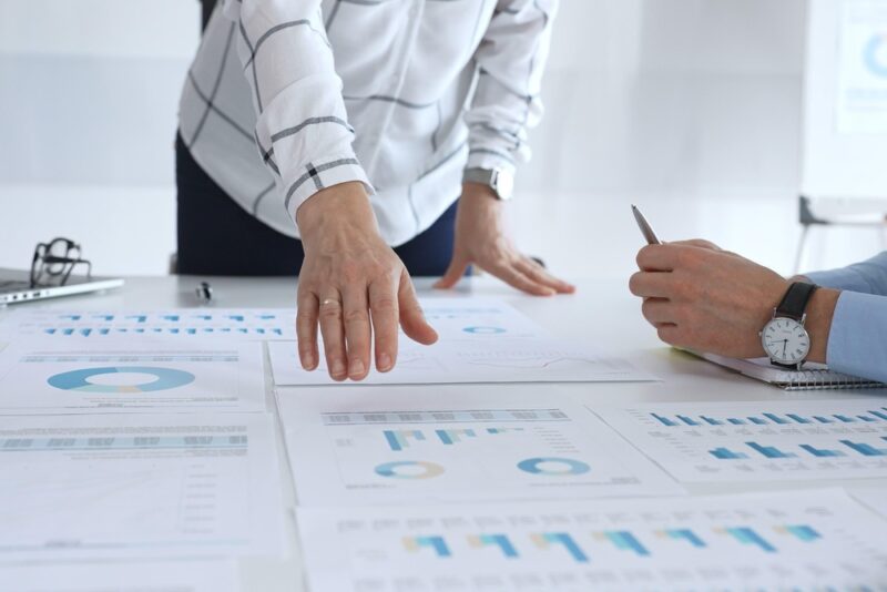 Data-driven workplace wellbeing analysis showing charts, metrics and business leaders reviewing impact and performance indicators