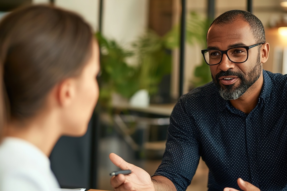 Manager and employee in conversation in an office setting, representing workplace discussions around neurodiversity support and reasonable adjustments