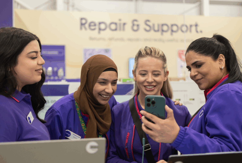 Currys employees interacting on shop floor with Retail Trust app, representing workplace wellbeing support in the retail sector