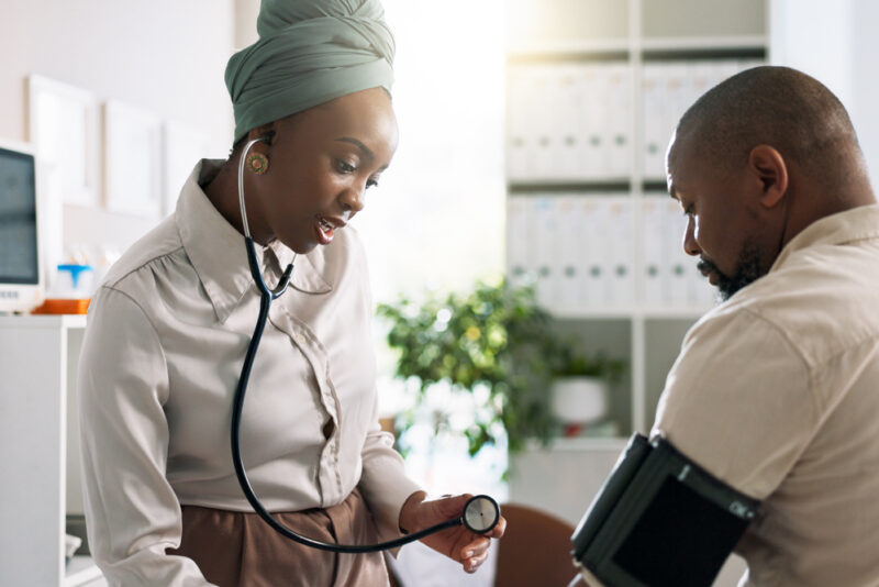 Workplace health screening event with employee having blood pressure and wellbeing checks in an office environment
