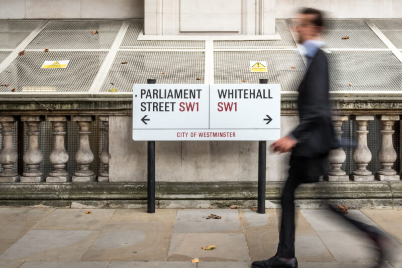 A man walking through Whitehall in London, symbolising UK government activity as ministers launch a new mental health strategy focused on prevention and early intervention.