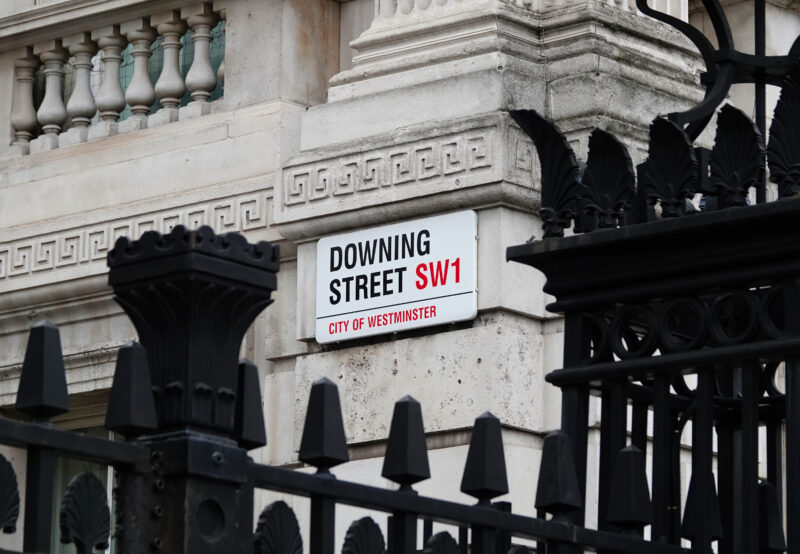 Close-up of the Downing Street street sign in London, symbolising UK political uncertainty and its potential implications for workplace health, wellbeing and employment policy.