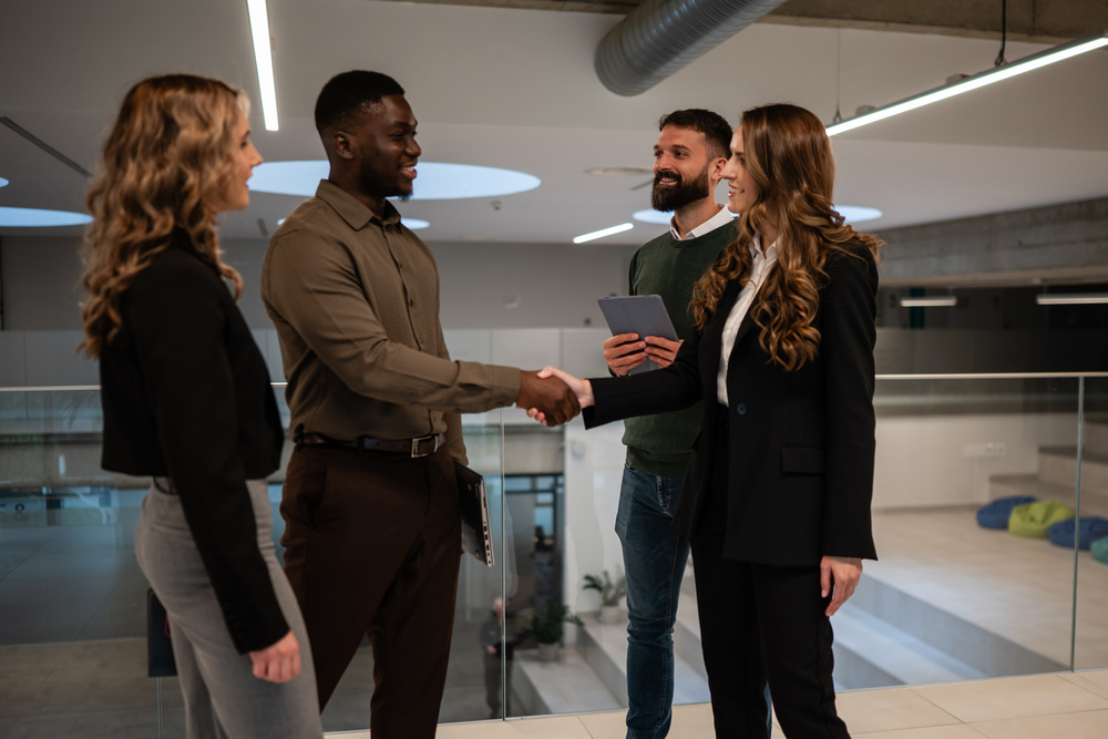 Diverse business professionals shaking hands in office building
