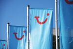 TUI logo displayed on branded flags outside a holiday venue, representing the company's commitment to building a neuro-inclusive workplace and customer experience.
