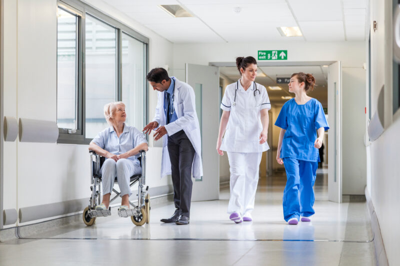 Group of NHS healthcare workers walking down a hospital corridor.