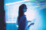 A young employee looks thoughtfully at a digital screen, illustrating the importance of maintaining human connection, wellbeing and mental health as AI transforms the workplace.