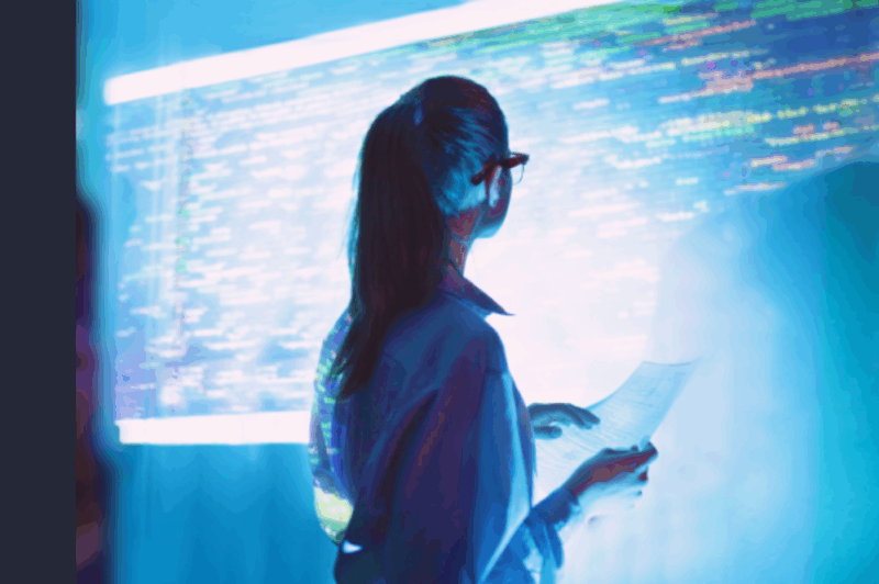 A young employee looks thoughtfully at a digital screen, illustrating the importance of maintaining human connection, wellbeing and mental health as AI transforms the workplace.