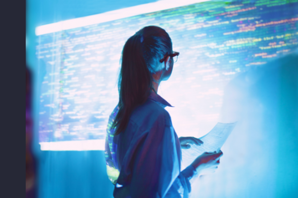 A young employee looks thoughtfully at a digital screen, illustrating the importance of maintaining human connection, wellbeing and mental health as AI transforms the workplace.
