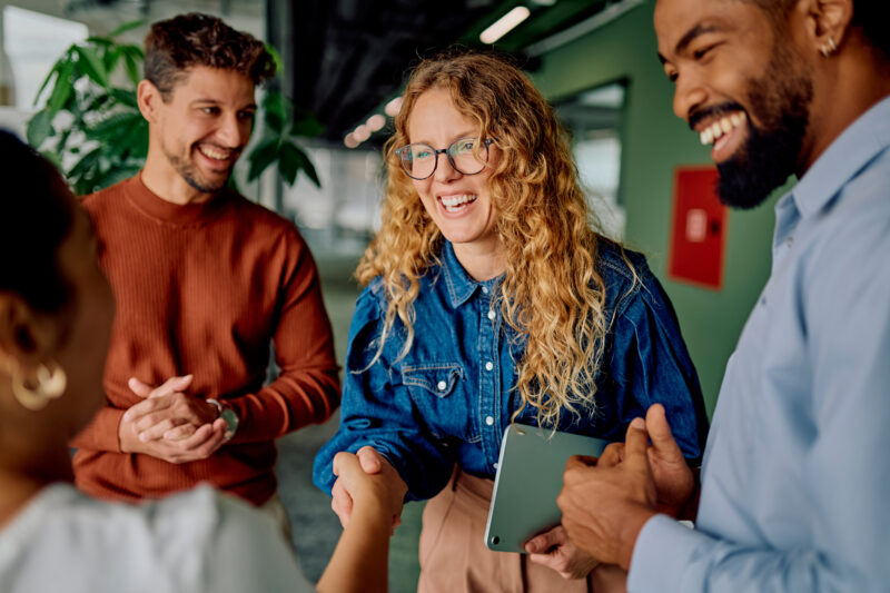 Diverse colleagues shaking hands in a modern workplace, representing collaboration, leadership transitions and professional connections.