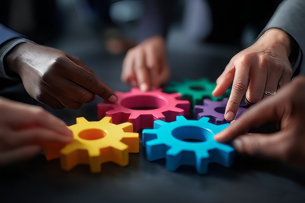 People at work holding cogs that fit together to show how an integrated approach makes everything work more smoothly