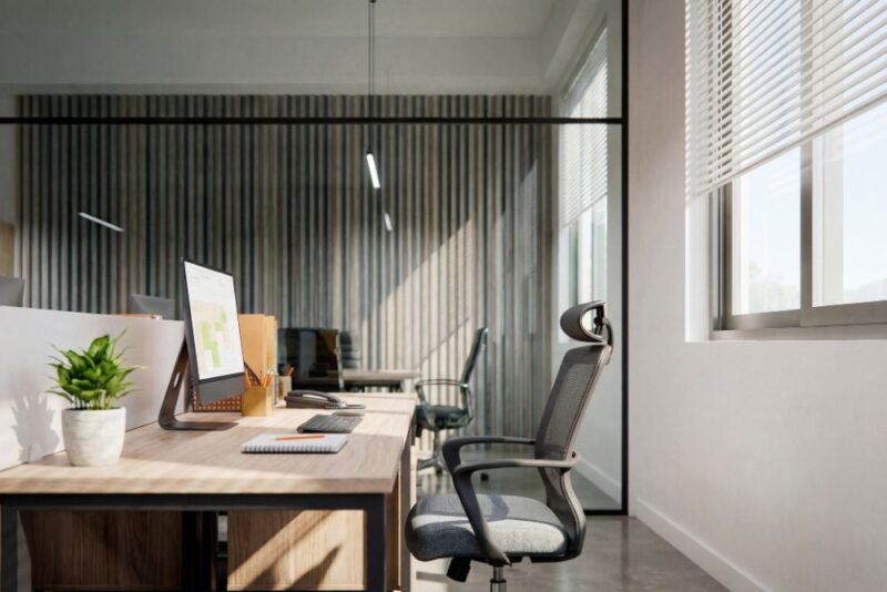 Bright and modern office workstation with computer monitor displaying graphs, near a sunlit window with blinds.