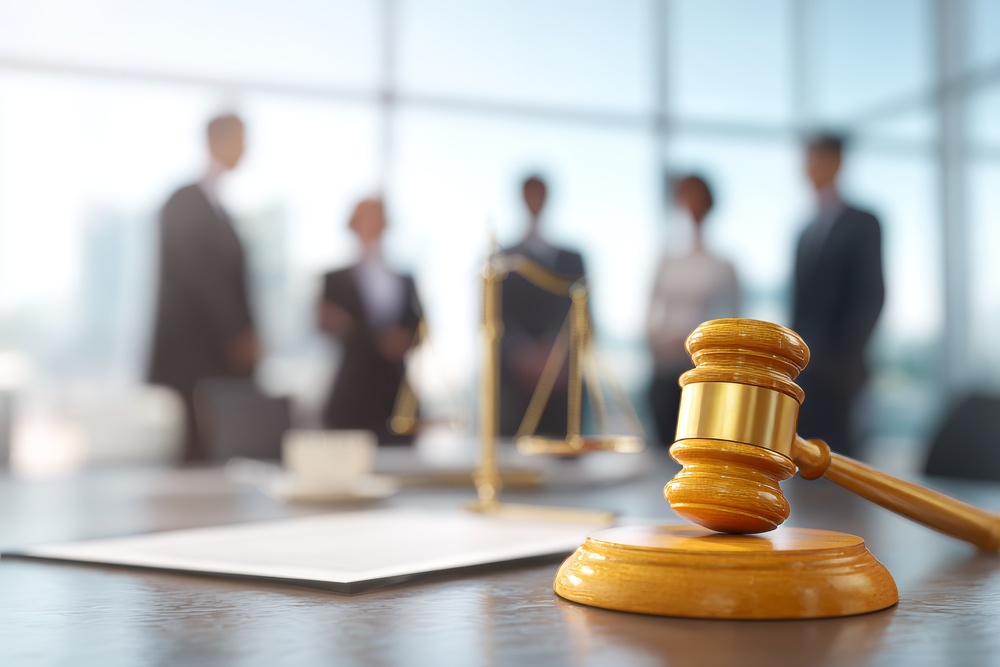 In a modern office, the discussion among lawyers revolves around contracts and legal documents, with the gavel and scales of justice embodying the legal system, and business people are diligent in