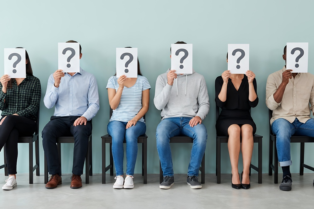 Six diverse individuals holding question marks to show that putting together a wellbeing strategy doesn't have to depend on guesswork.