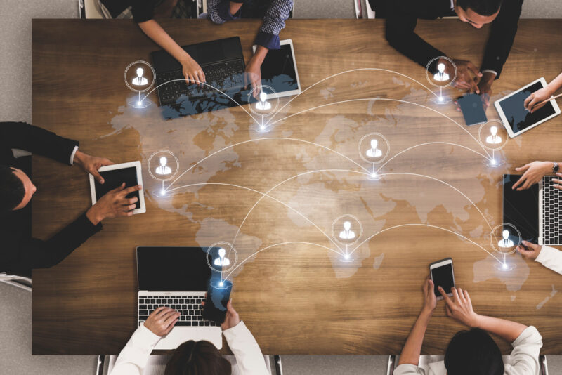 Employers discussing global employee health and wellbeing around a world map