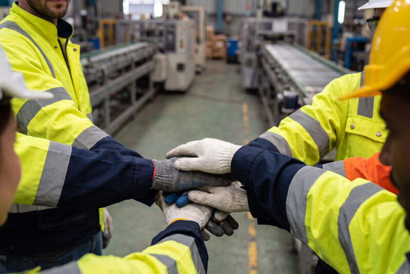 Team of night shift workers joining hands in a show of teamwork and support