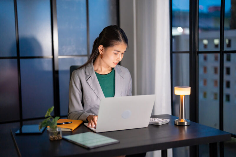 Employee working alone at her laptop late in the office