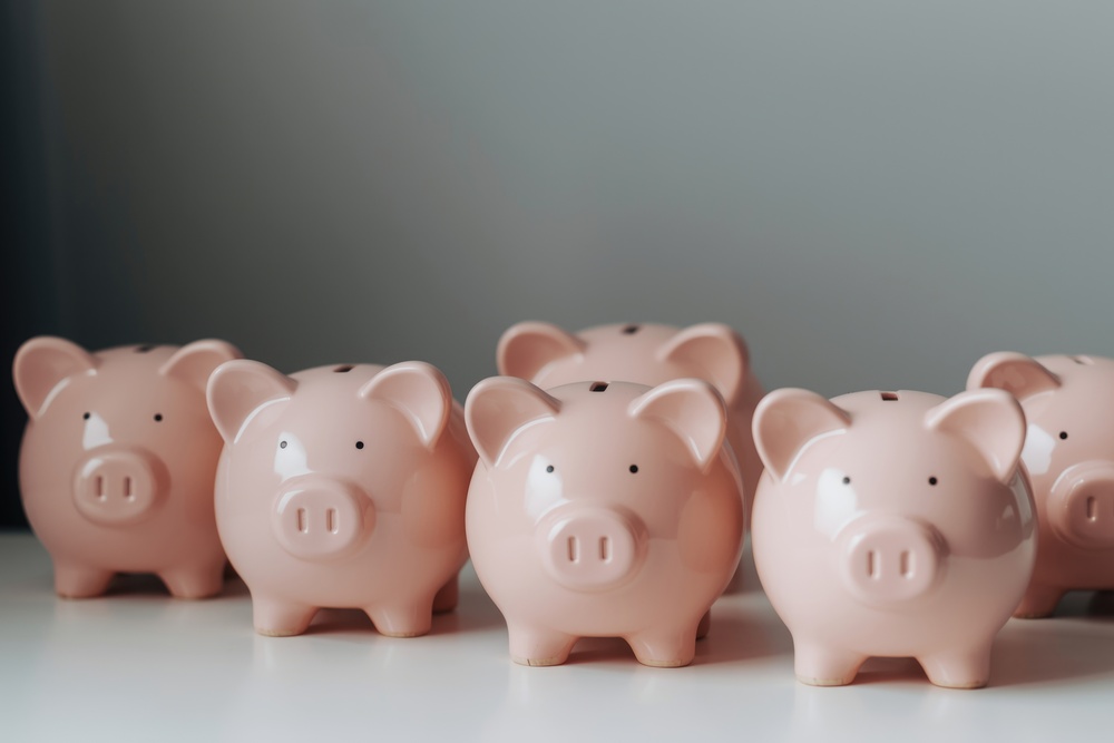 Group of pink china piggy banks representing workplace savings and financial wellbeing
