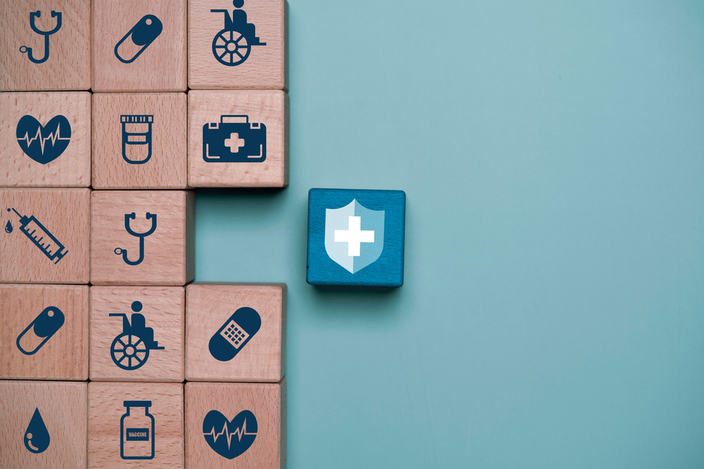 Wooden blocks, each with different health-related symbols showing the need for an interconnected approach to workforce health
