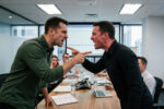 Two senior leaders openly disagreeing during a boardroom meeting