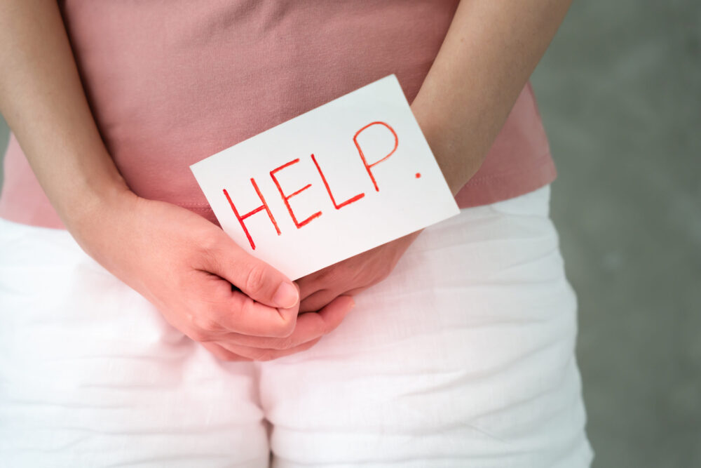 Woman holding a help sign in front of her body