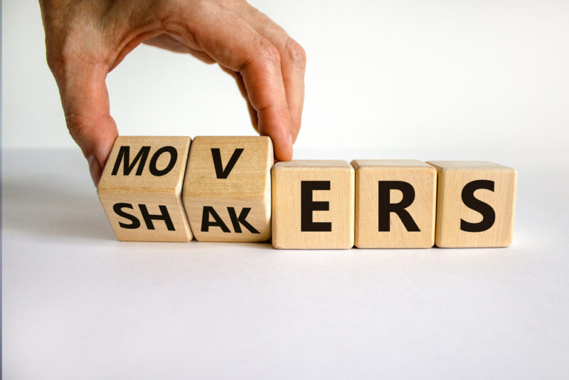A hand moving wooden blocks to shift from spelling the word Movers to Shakers