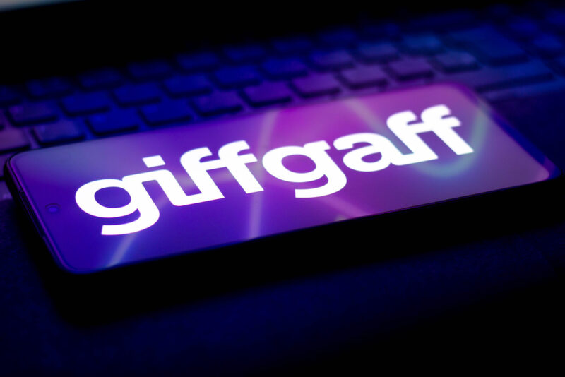 giffgaff logo illuminated on a mobile phone lying on a laptop keyboard