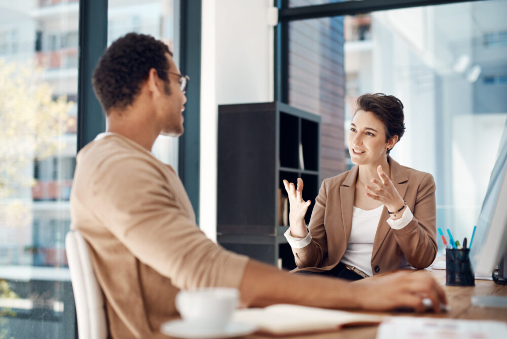 Female employee having a comfortable and confident conversation with her male manager about workplace support.