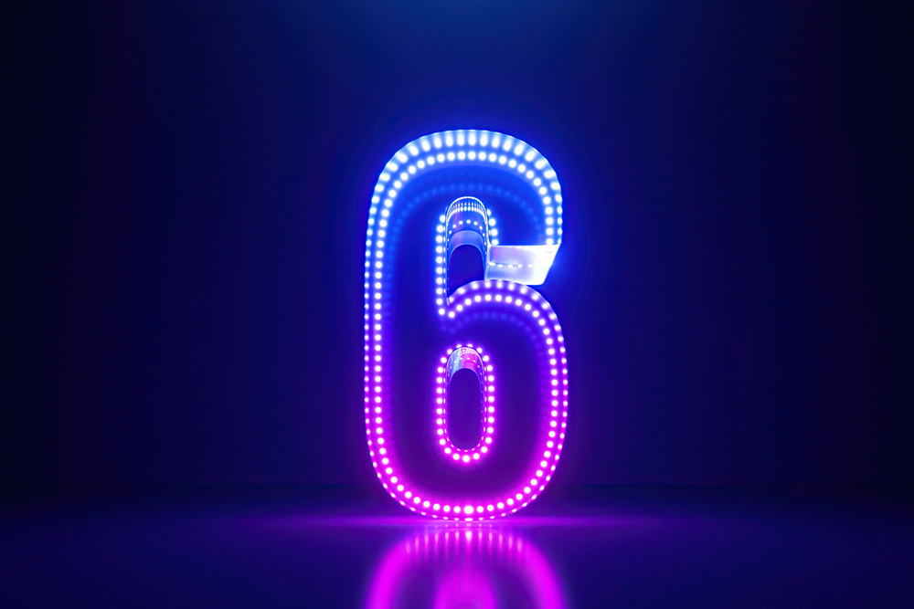 Neon number six against a black background to denote 6 big themes shaping healthier workplaces