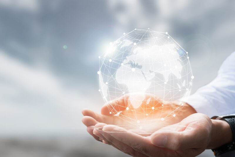 Business man holding a glass world globe in his hands