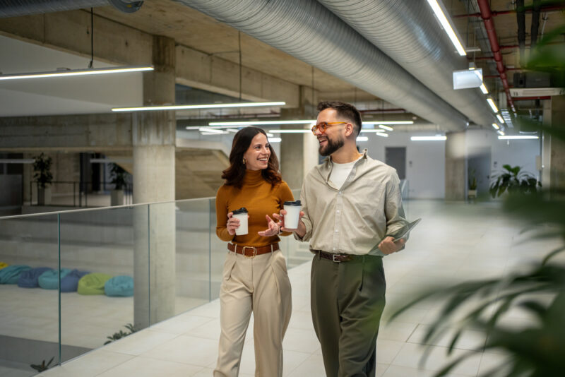 Colleagues walking and talking together in the workplace.Colleagues walking and talking together in the workplace.