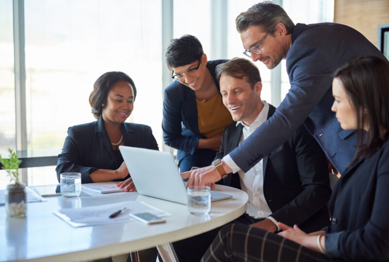 Group of accountants working happily and happy on laptop in boardroom with strategy or idea on project, teamwork and collaboration.